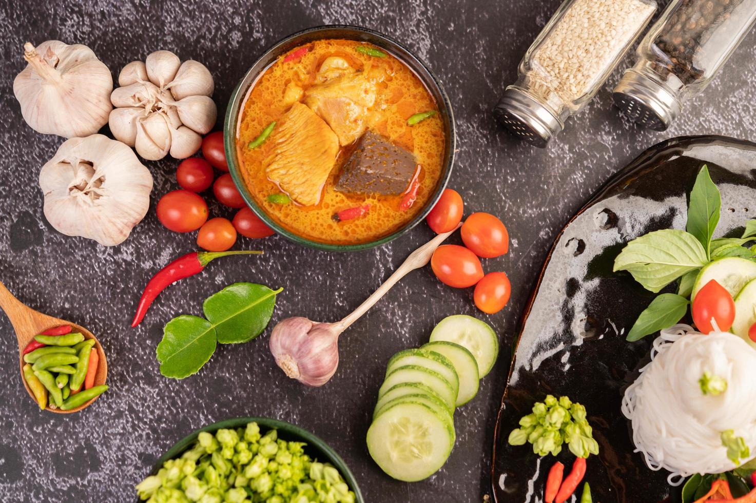 curry de frango em uma xícara preta com macarrão de arroz foto