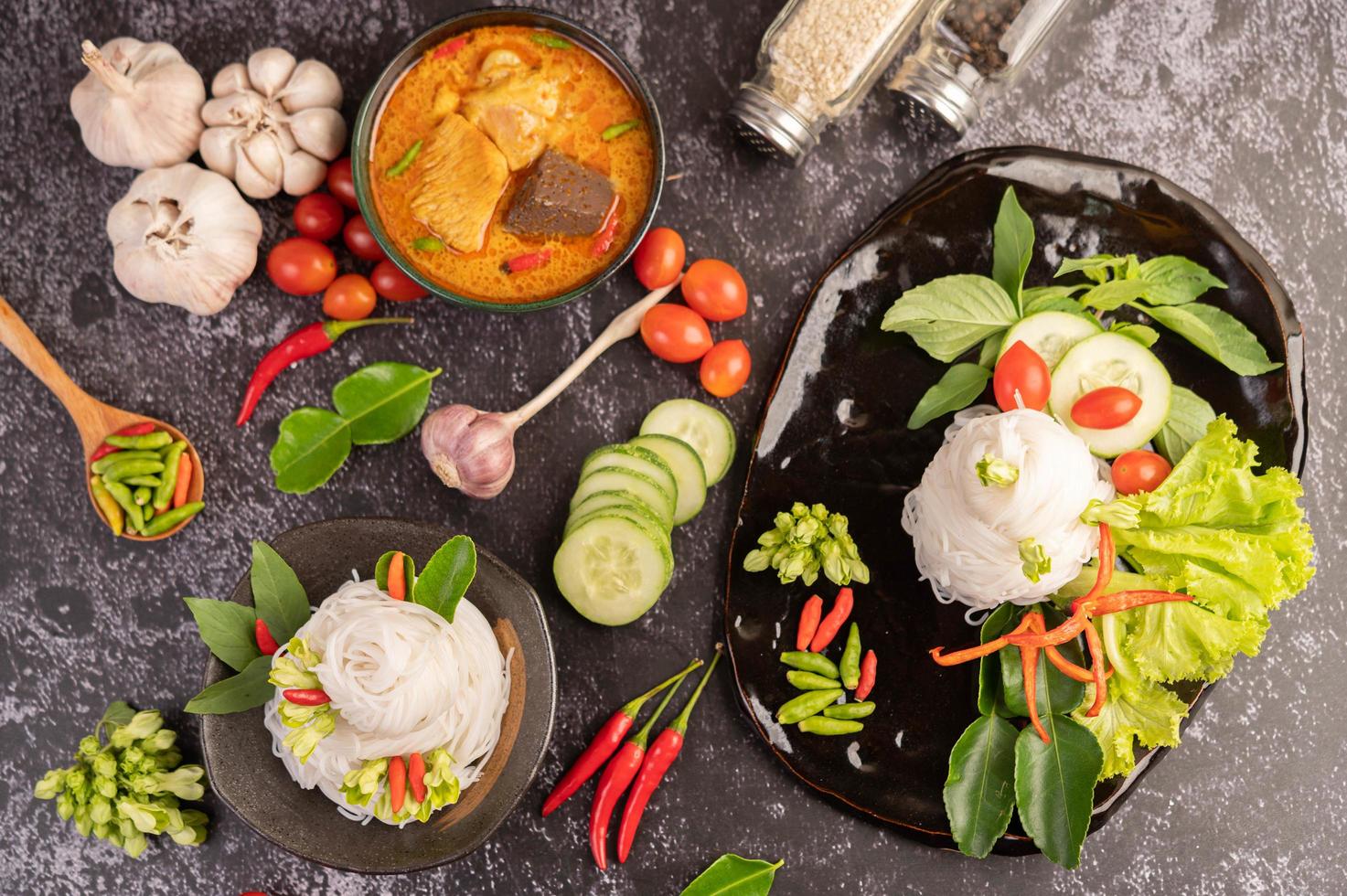 curry de frango em uma xícara preta com macarrão de arroz foto