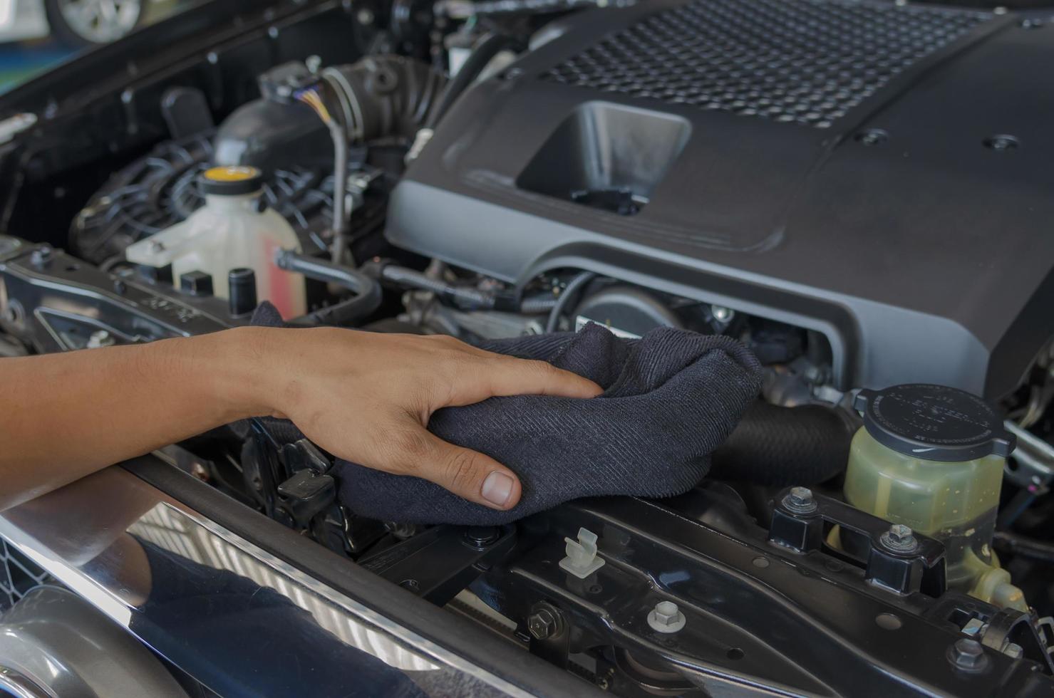 mecânico verifica e limpa o motor do carro foto