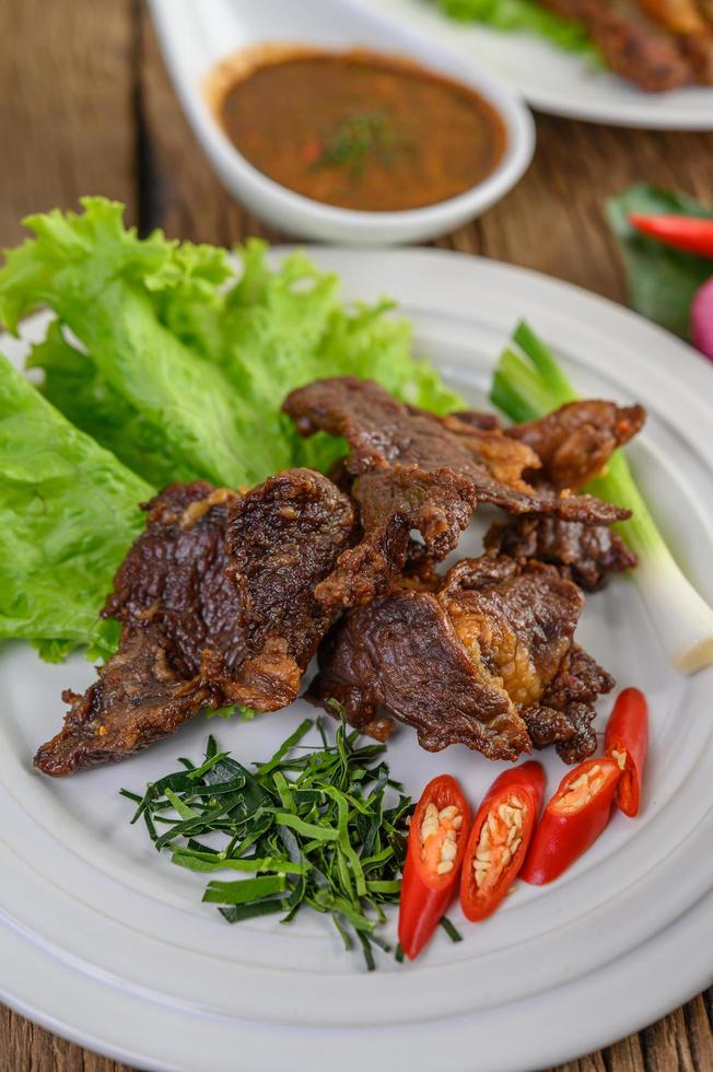 carne comida tailandesa frita com cebolinha, limão, pimenta e salada foto