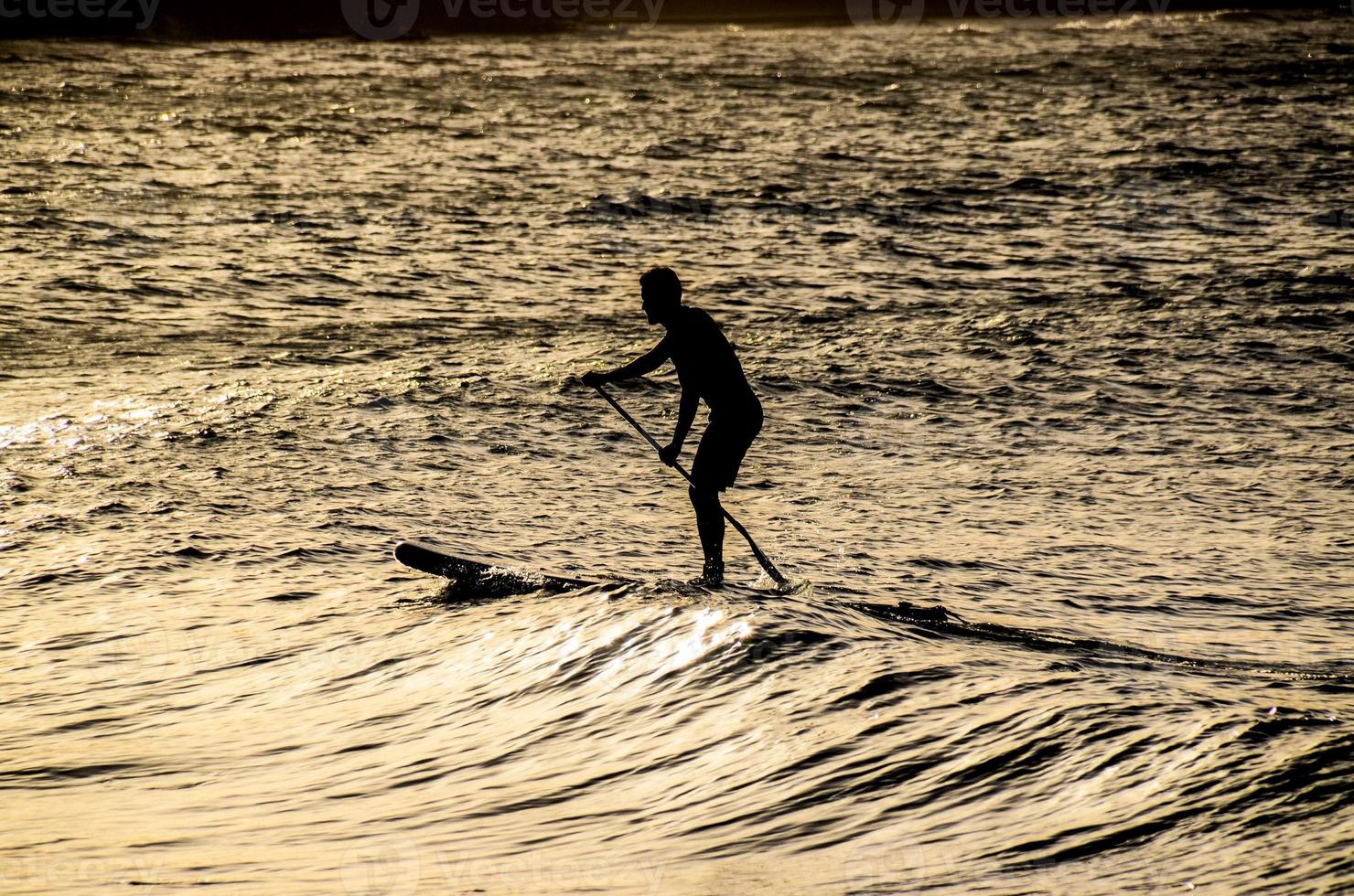 surfista ao pôr do sol foto