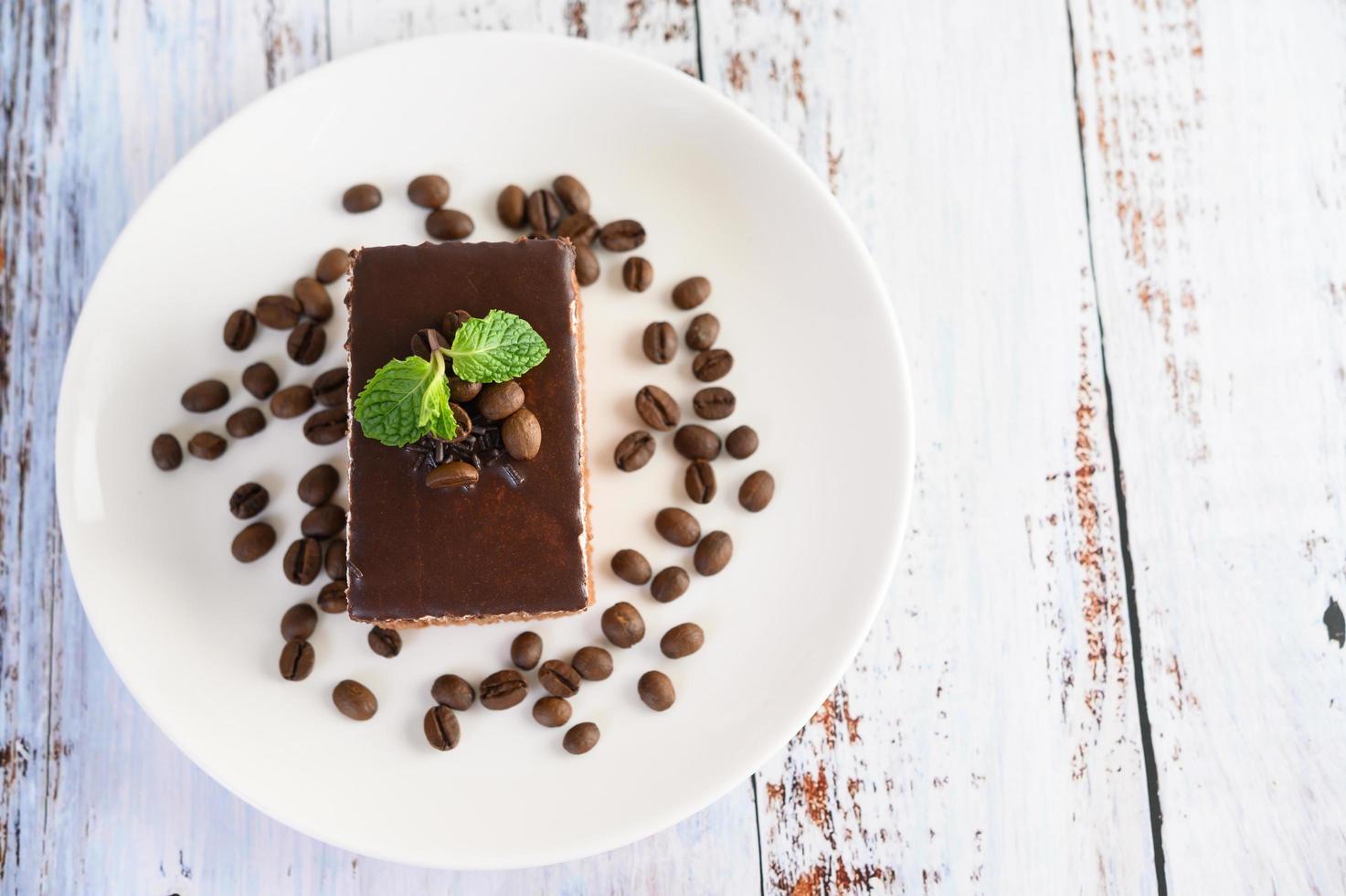 Bolo de chocolate com grãos de café em uma superfície de madeira foto