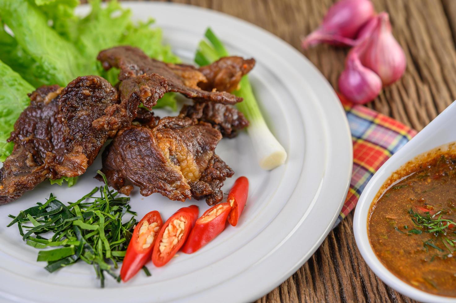 carne frita comida tailandesa na mesa de madeira foto