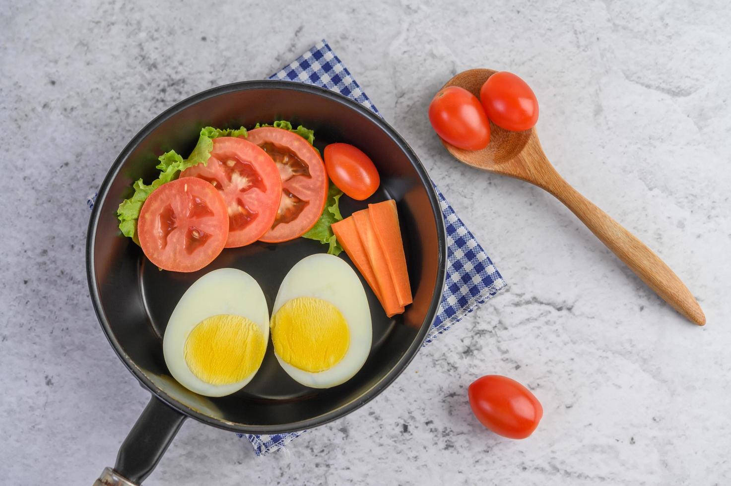 ovos cozidos, cenouras e tomates em uma panela com tomates foto