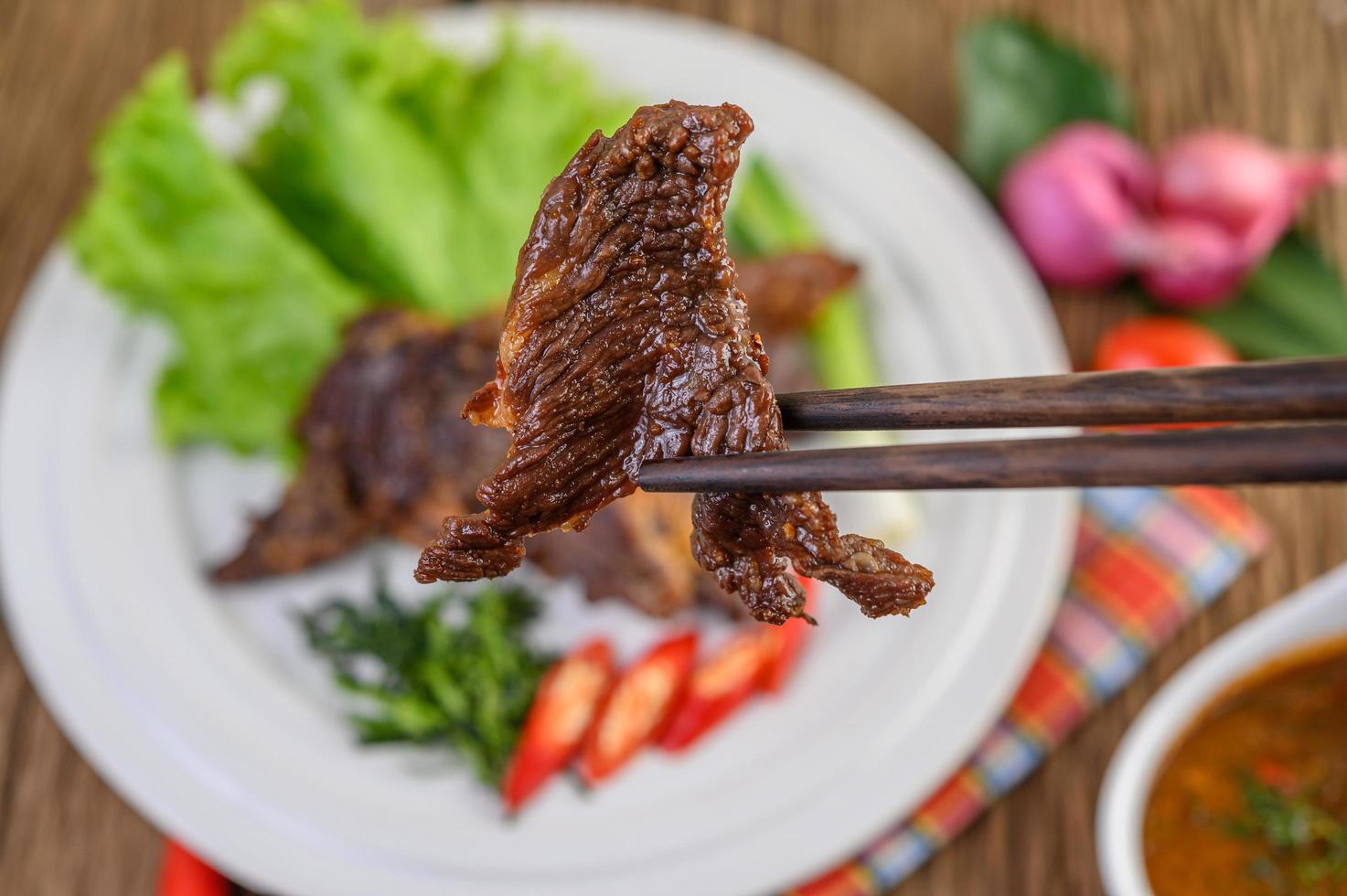 carne frita comida tailandesa na mesa de madeira foto