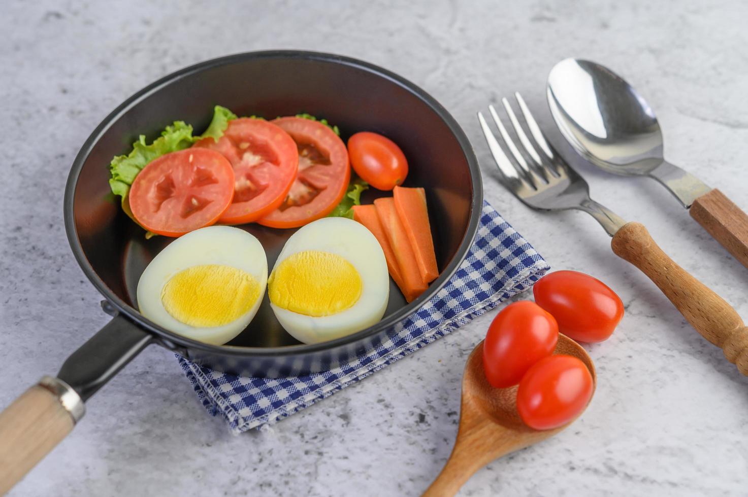 ovos cozidos, cenouras e tomates em uma panela com tomates foto