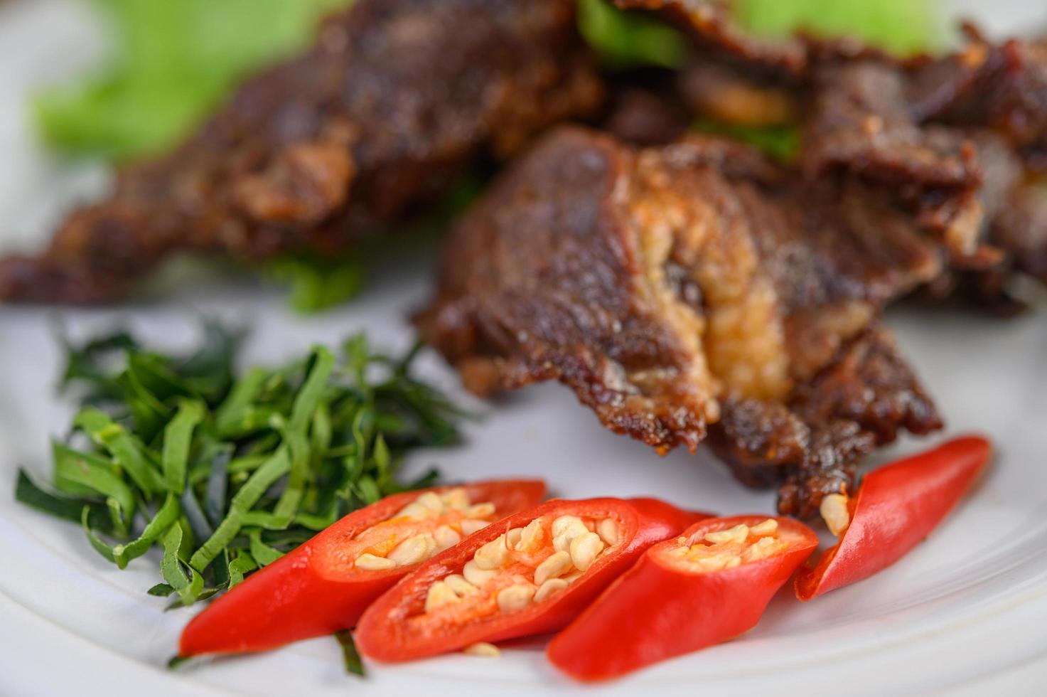 carne comida tailandesa frita com cebolinha, limão, pimenta e salada foto