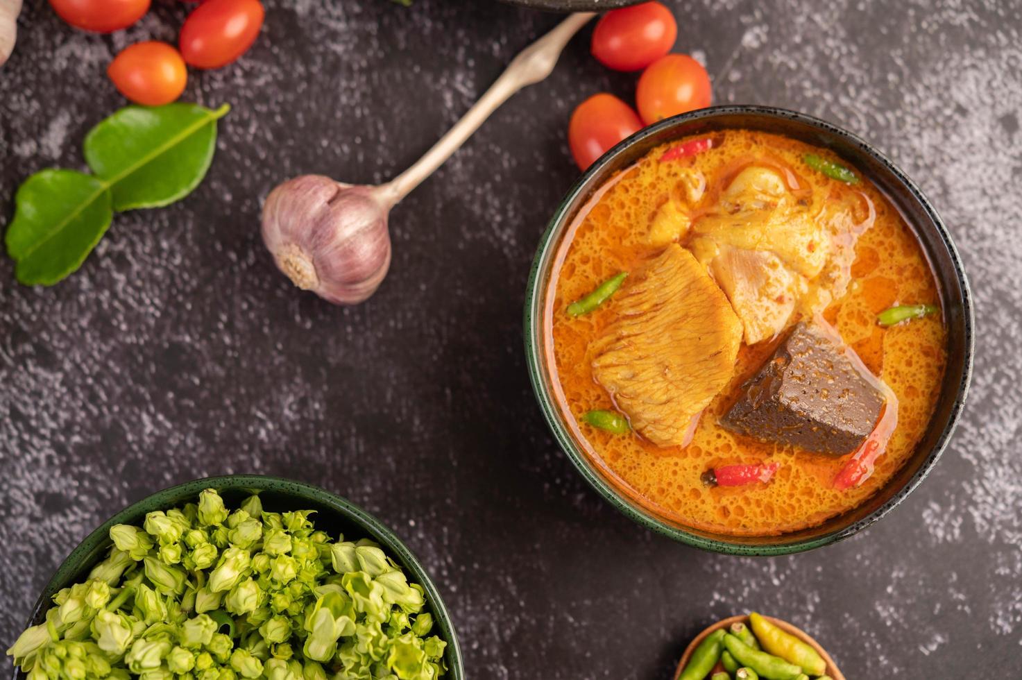 curry de frango em uma xícara preta com alho e pimenta foto