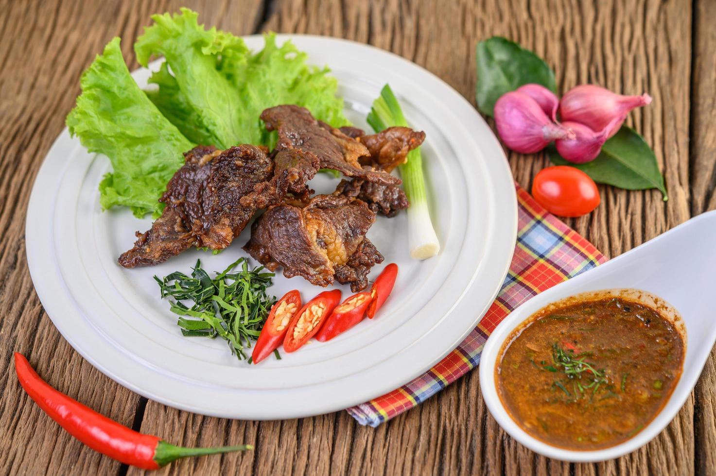 carne frita comida tailandesa na mesa de madeira foto