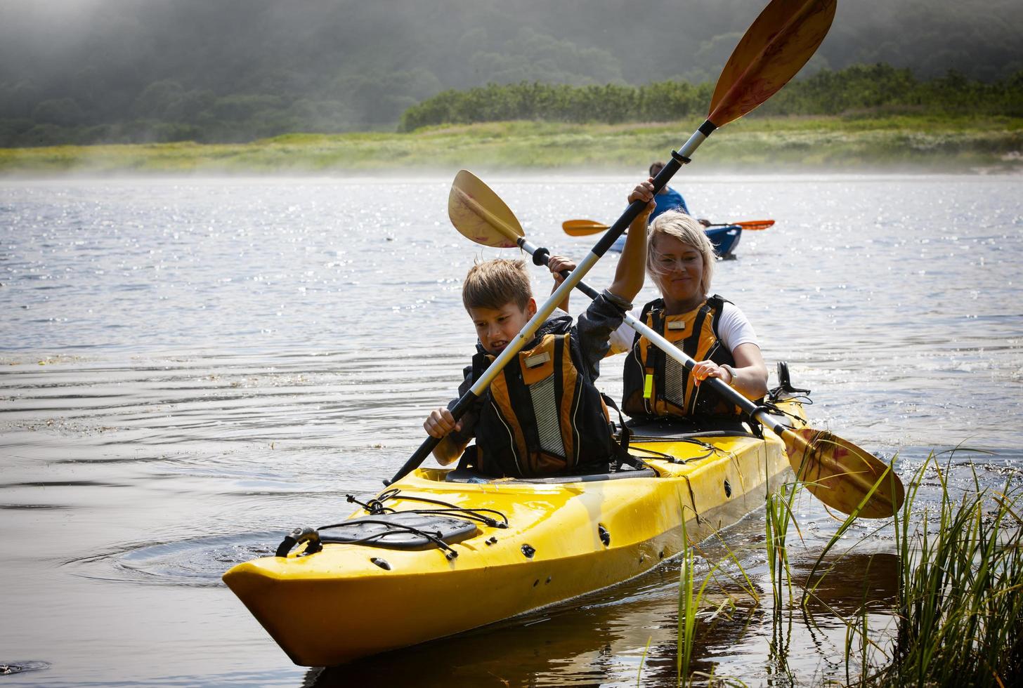 kamchatka, rússia- 10 de junho de 2021 - a mulher com uma criança no lago e andar de caiaque foto