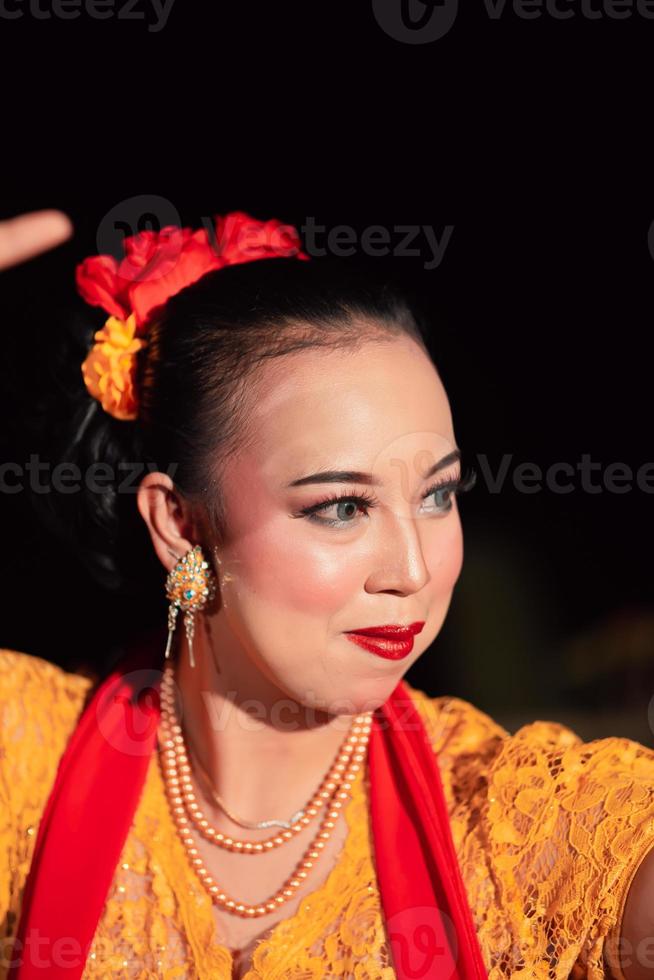 linda mulher asiática com maquiagem e acessórios de flores no cabelo enquanto usava joias de ouro foto