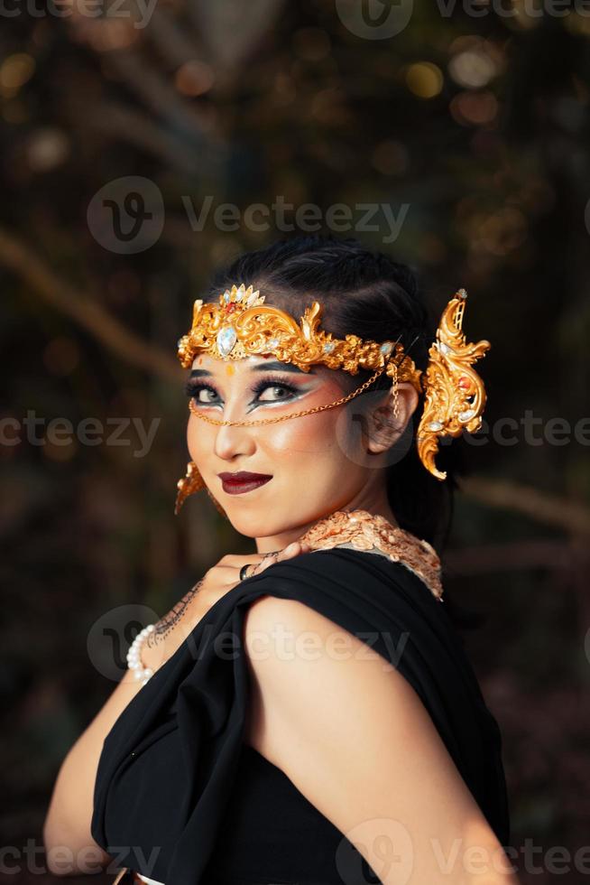 o rosto de uma mulher balinesa usando uma coroa de ouro e maquiagem no rosto com uma pele linda arrepiante foto