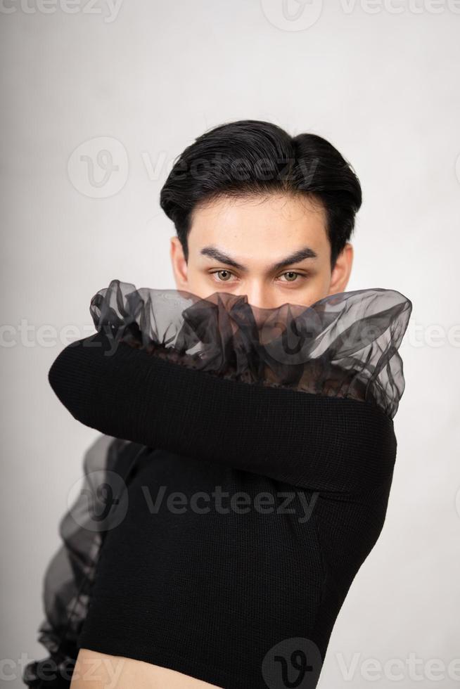 o homem bonito tinha estilo em um traje preto com cabelos pretos e um rosto bonito foto