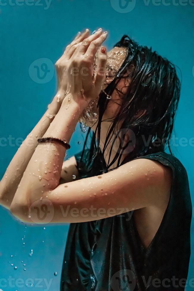 retrato de mulher indonésia tomando banho no chuveiro enquanto usava um vestido preto foto