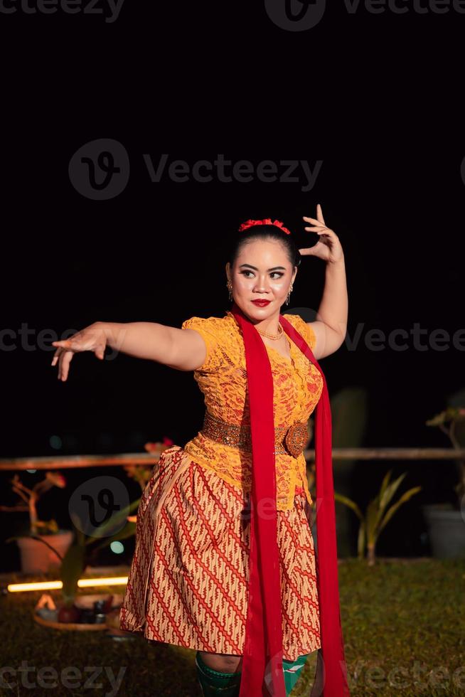 mulher sundanesa com rosto exótico usando vestido amarelo e lenço vermelho durante uma exposição de dança foto