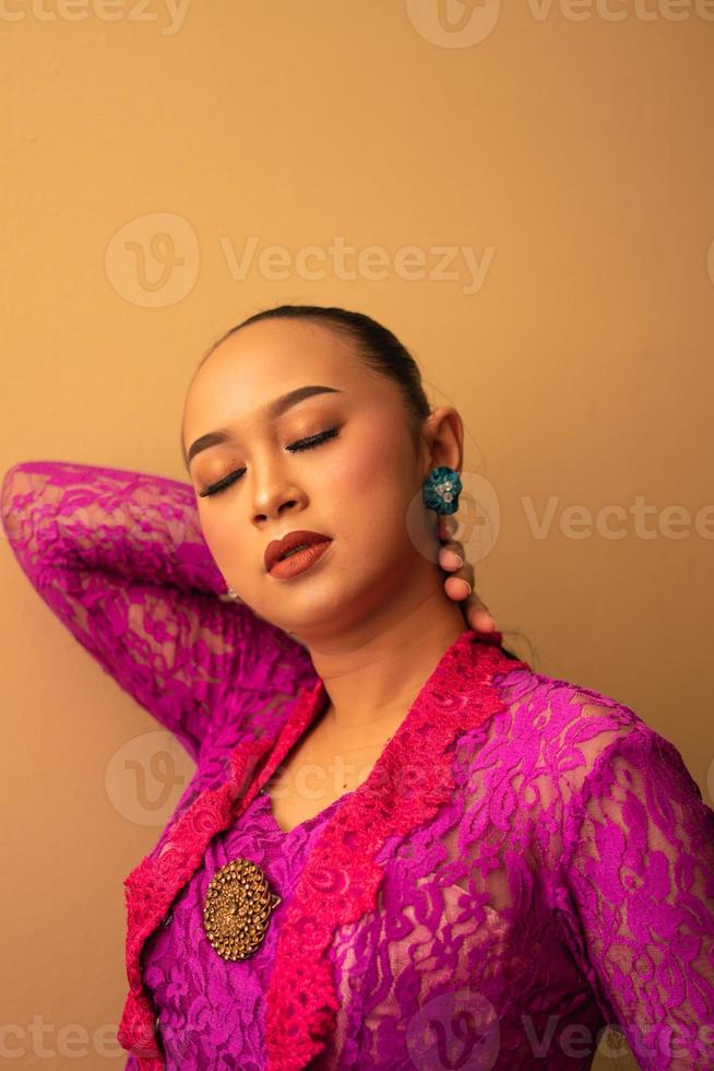 mulher asiática toca a cabeça enquanto posa com maquiagem foto