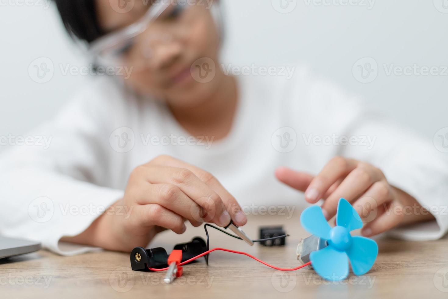 os alunos da ásia aprendem em casa na codificação de carros robóticos e cabos de placa eletrônica em haste, vapor, código de computador de tecnologia de ciência de engenharia matemática em robótica para o conceito de crianças. foto