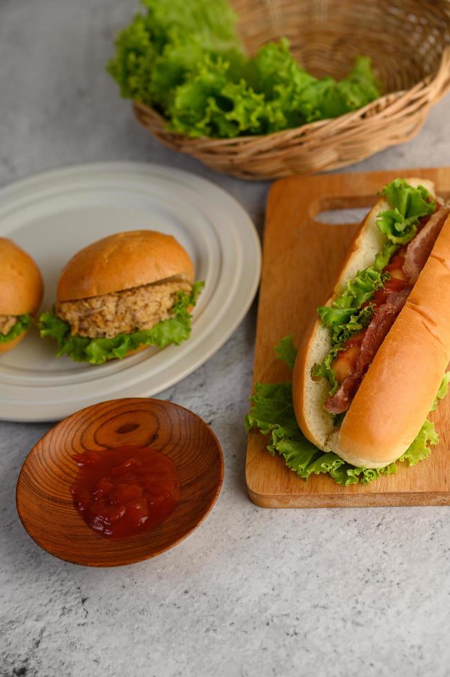 hambúrgueres e cachorro-quente com alface e molho de tomate foto