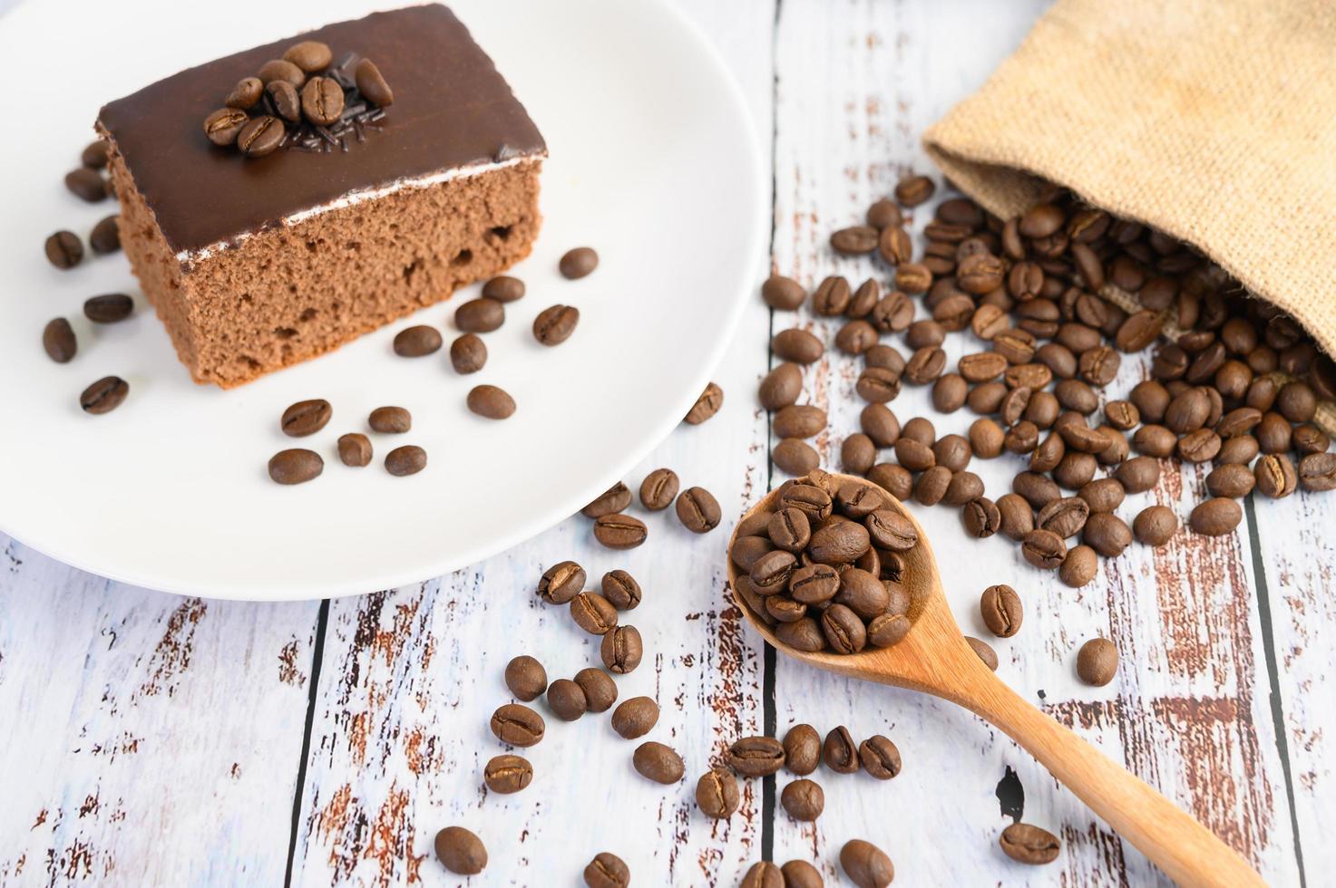 bolo de chocolate em um prato branco e grãos de café foto