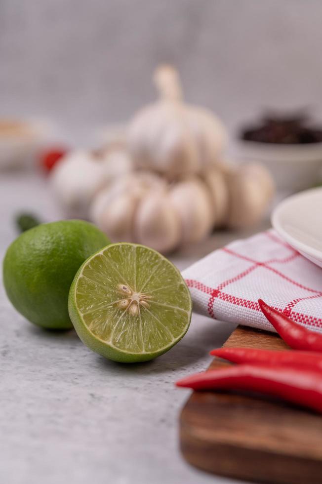 limão cortado ao meio com pimenta e alho em um fundo branco foto