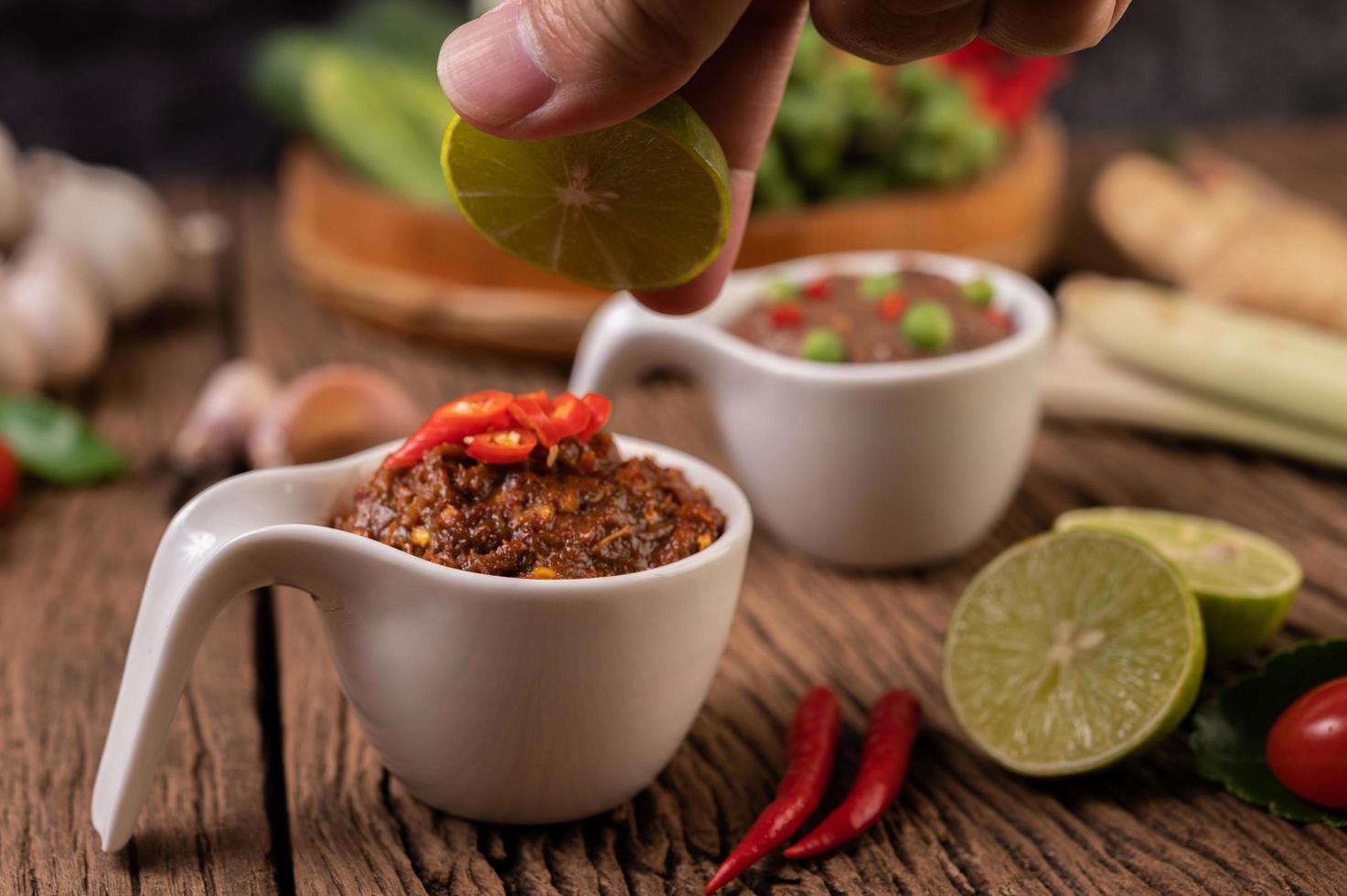 pasta de chili de olhos vermelhos com limão e chili na placa de madeira foto