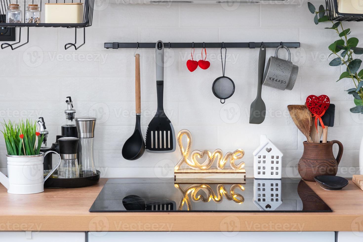 o interior da cozinha da casa é decorado com corações vermelhos para o dia dos namorados. decoração na mesa, fogão, utensílios, clima festivo em ninho familiar foto