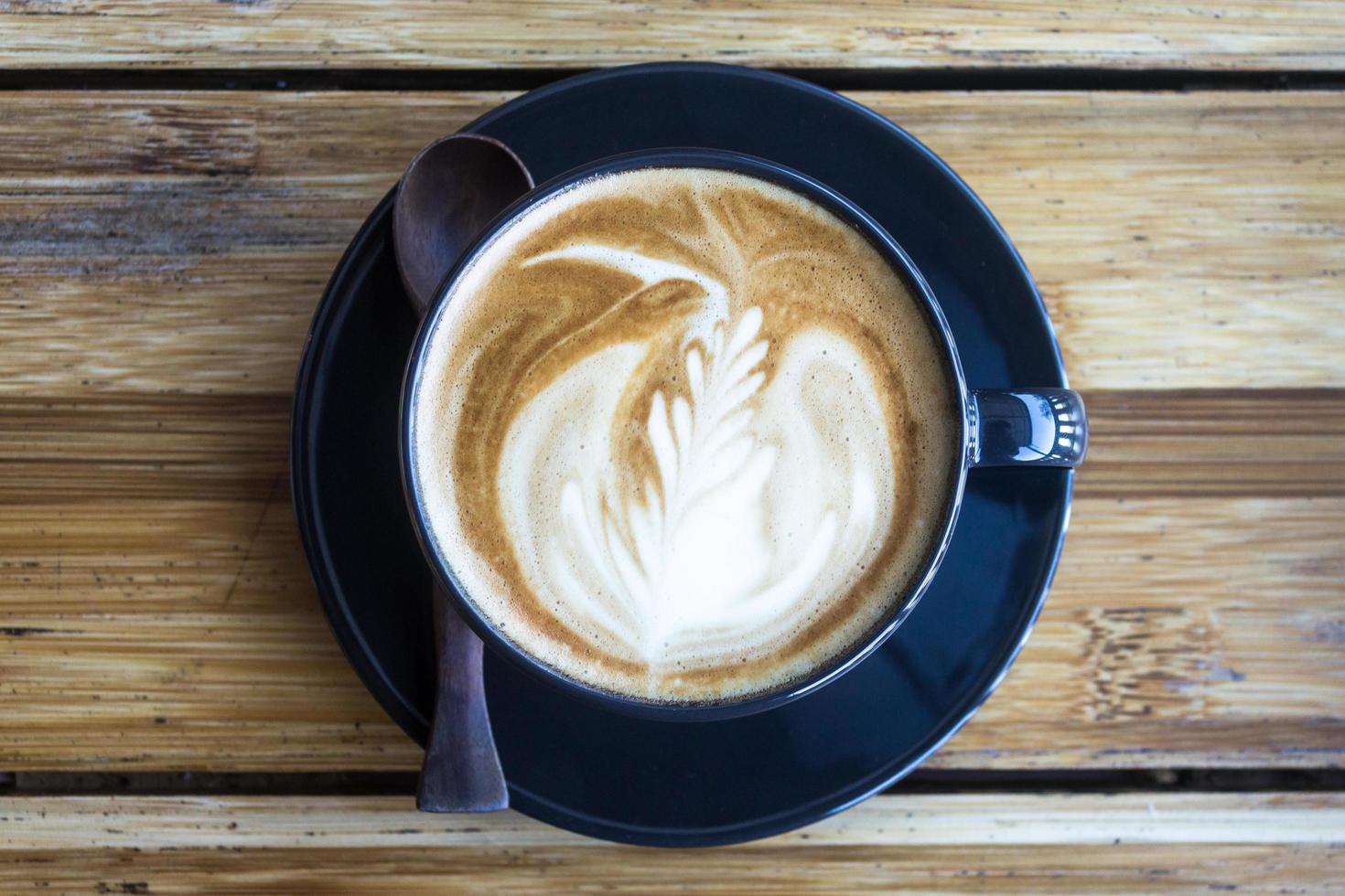 café com latte art na mesa de madeira foto