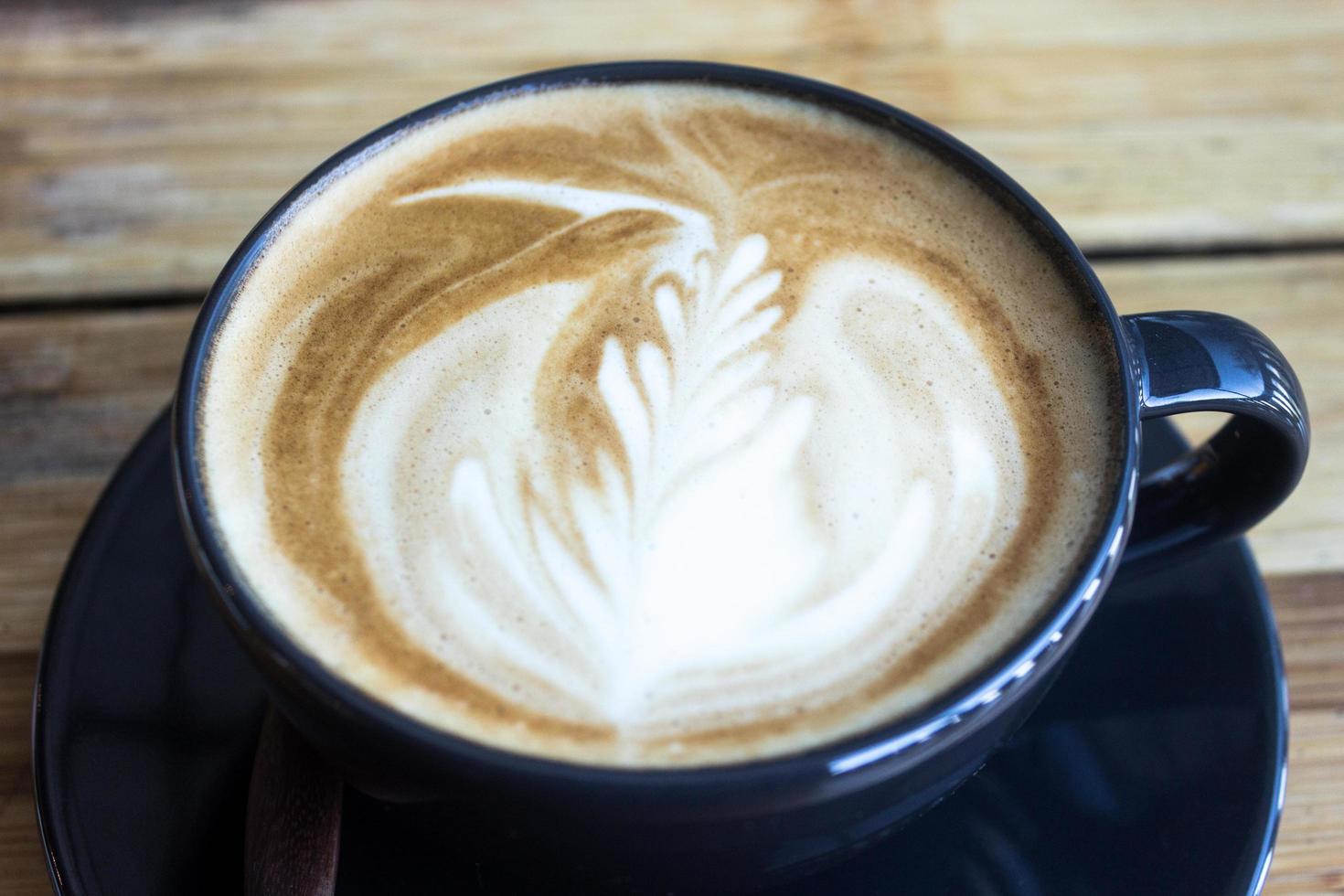 café com latte art na mesa de madeira foto