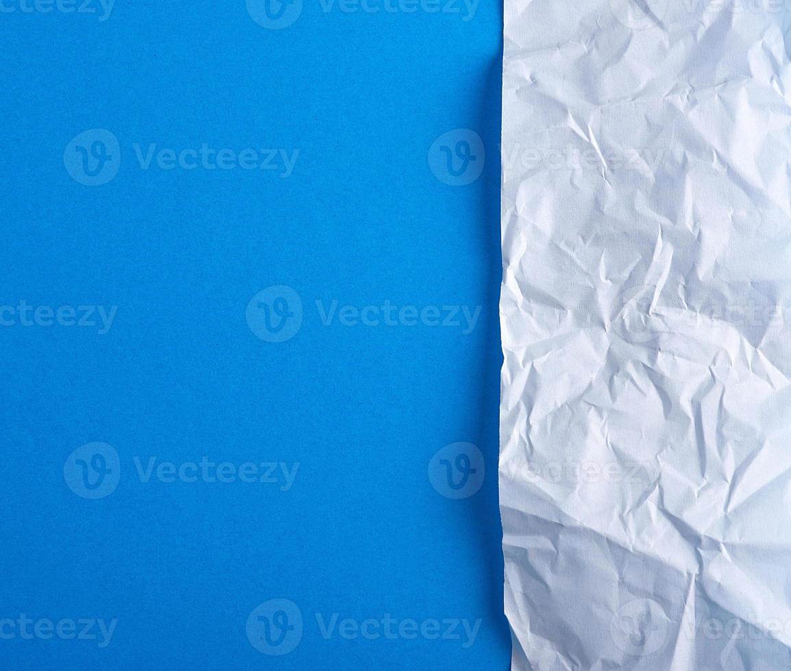 papel branco amassado em um fundo azul foto