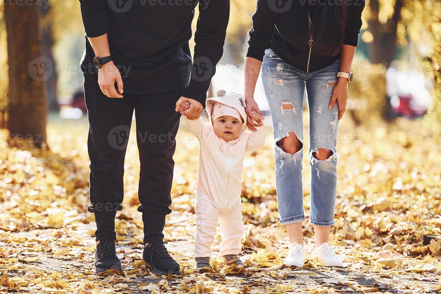 vista de perto. família alegre se divertindo junto com seu filho no belo parque outono foto