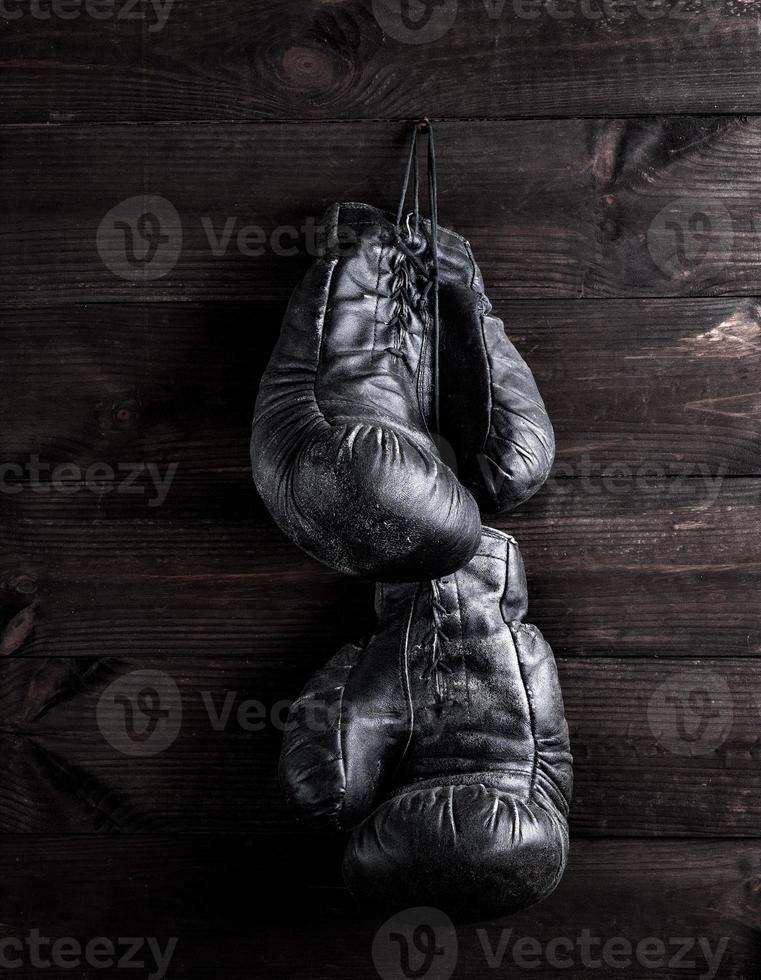 luvas de boxe de couro preto penduradas em um prego foto