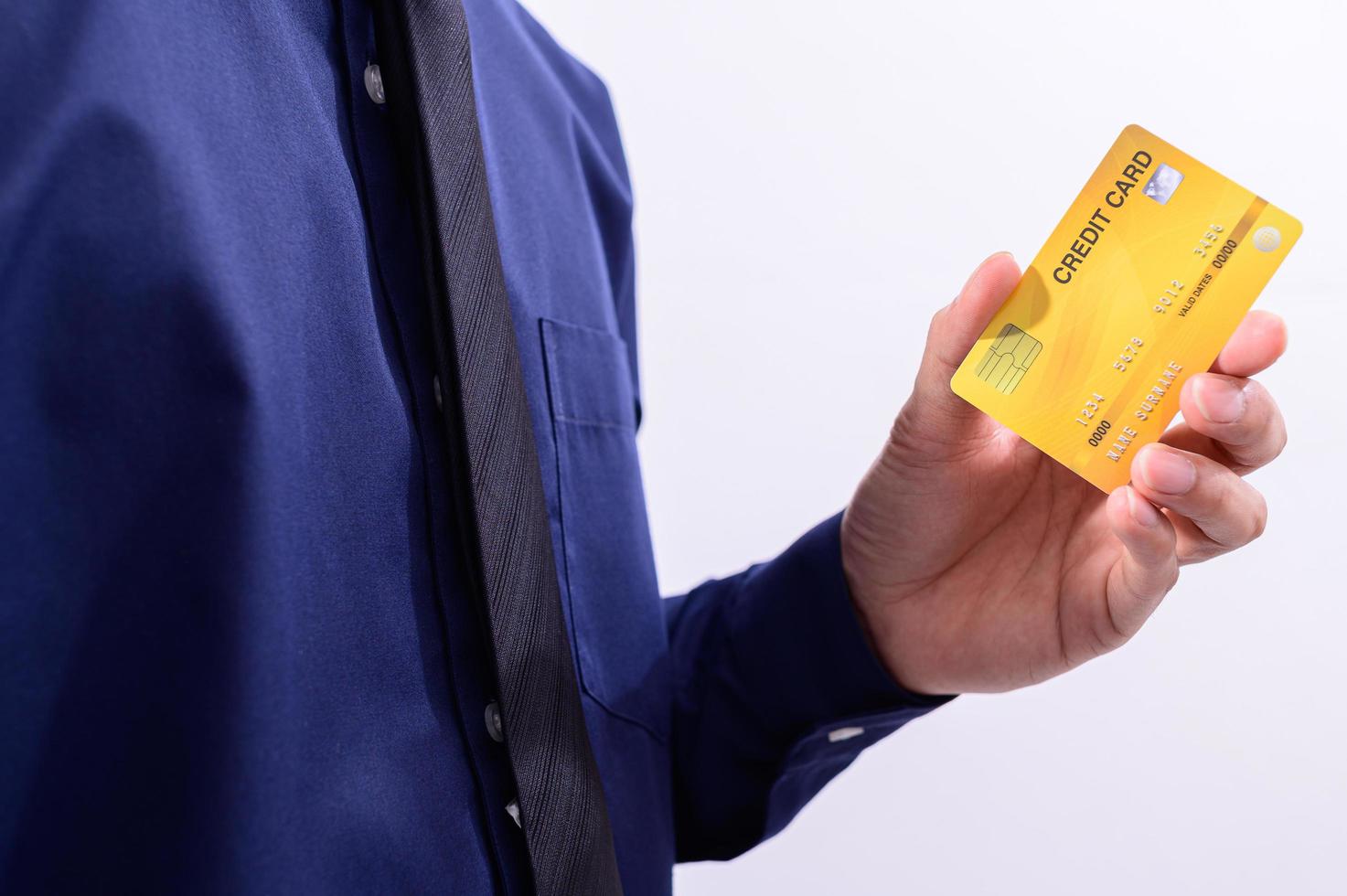homem segurando um cartão de crédito amarelo foto