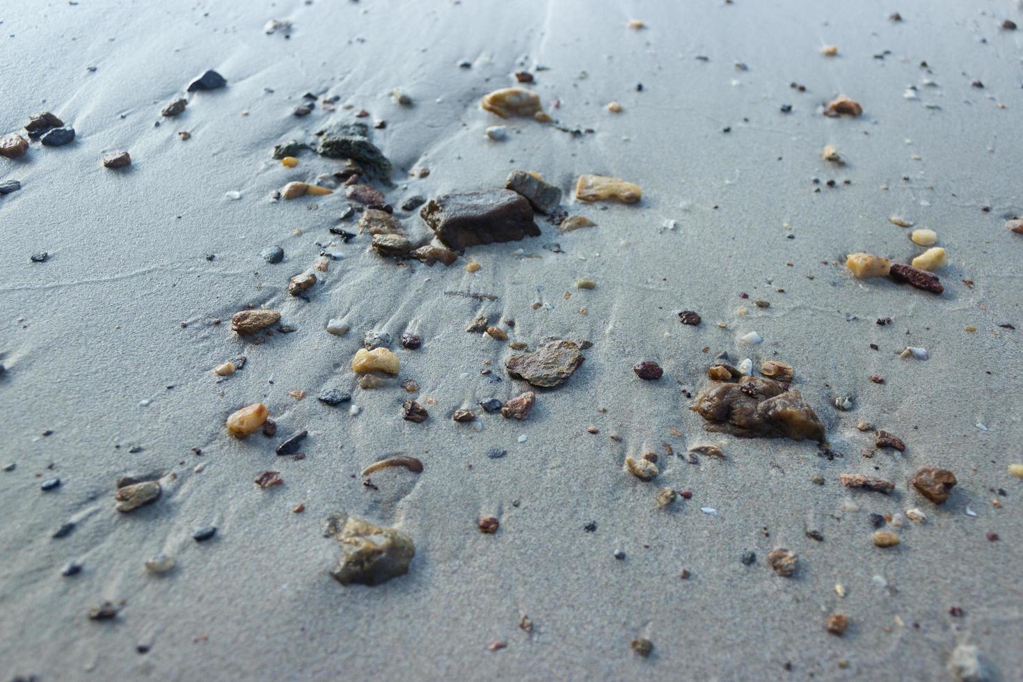 seixos na areia cinza foto