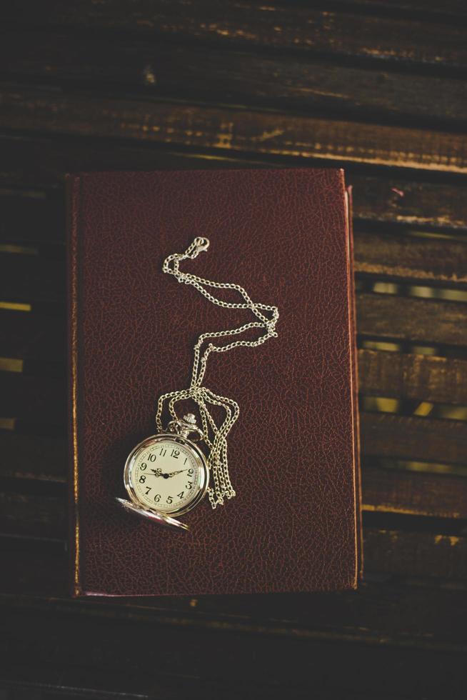 close up de um relógio de bolso vintage em livros antigos foto