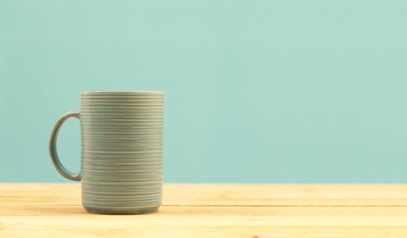 xícara de café verde na mesa de madeira foto