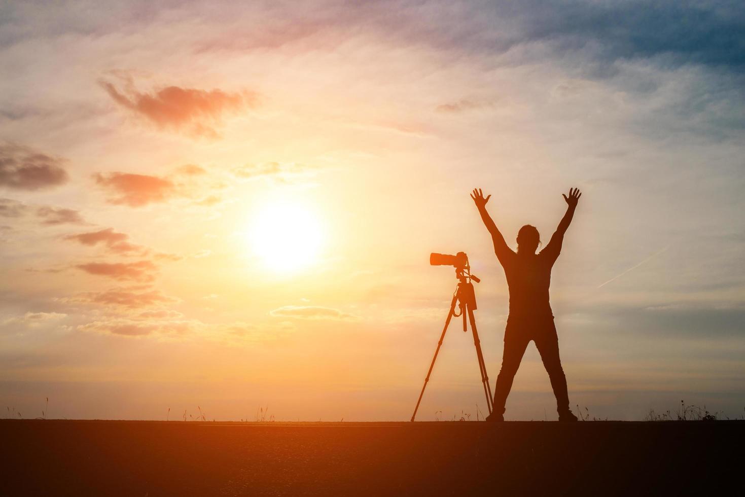 silhueta de um fotógrafo fotografando ao pôr do sol foto