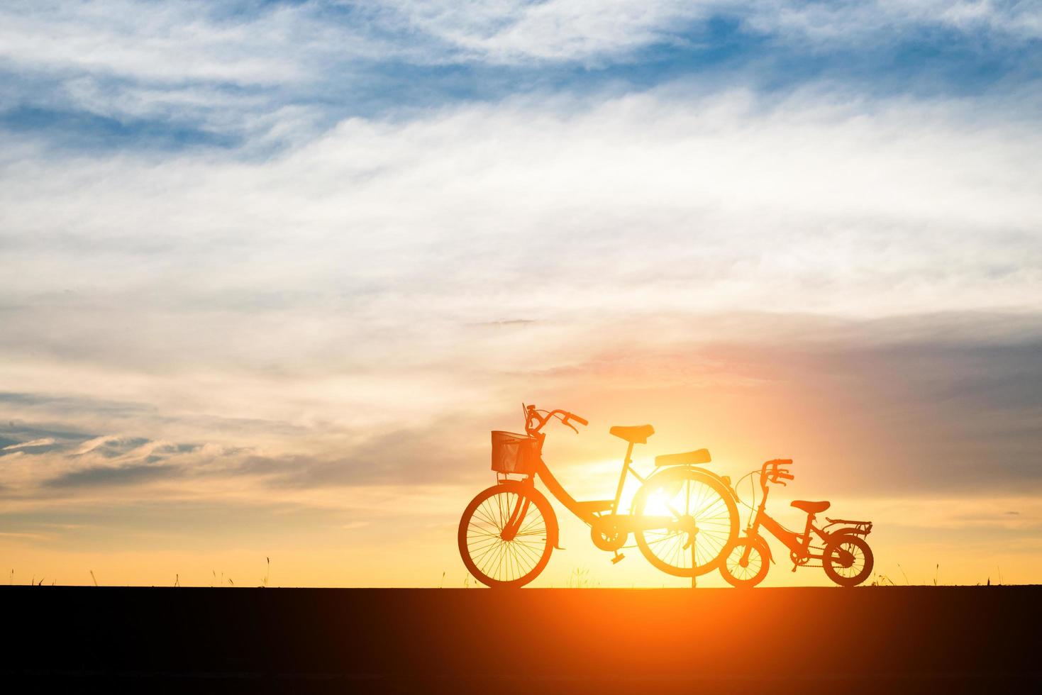 duas bicicletas de silhueta vintage ao pôr do sol foto