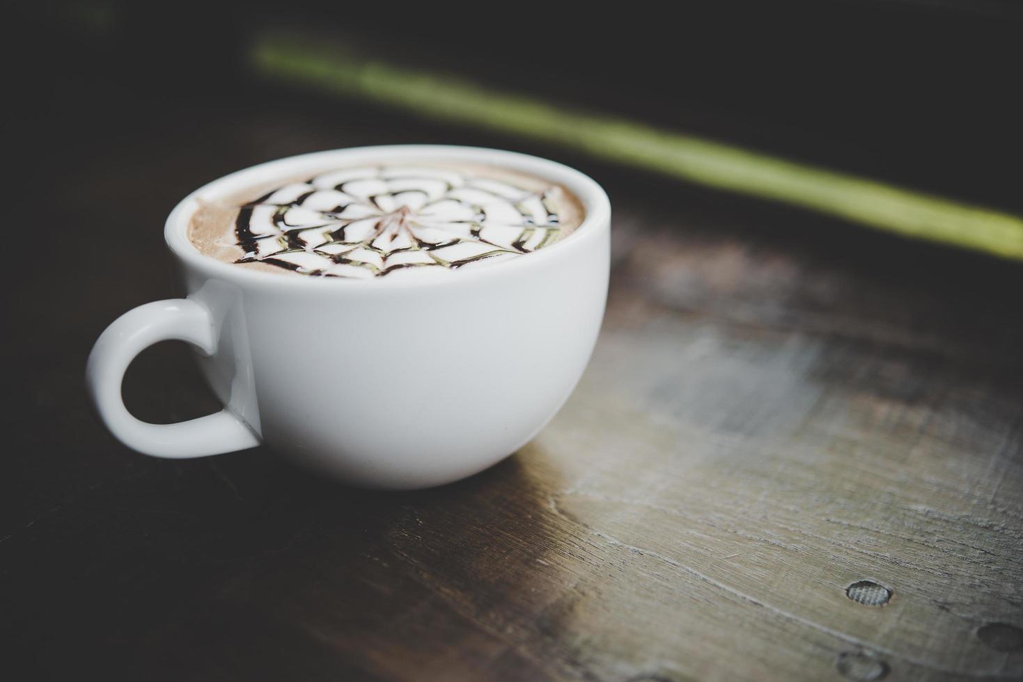 uma xícara de café em uma mesa de madeira foto