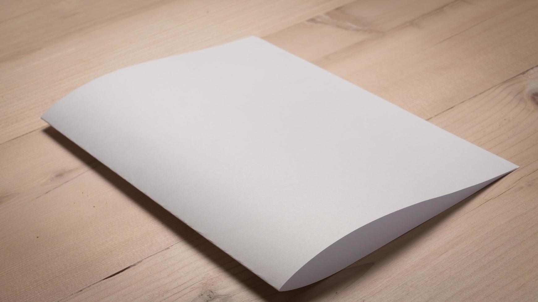 papel branco dobrado em branco na mesa de madeira foto