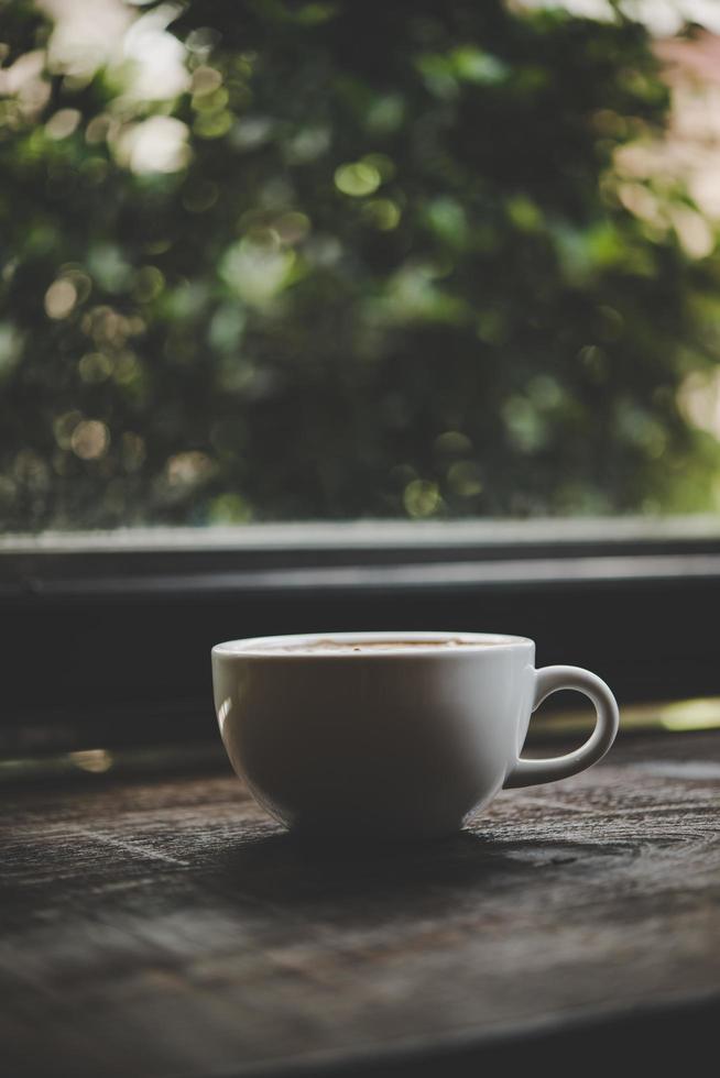 uma xícara de café em uma mesa de madeira foto