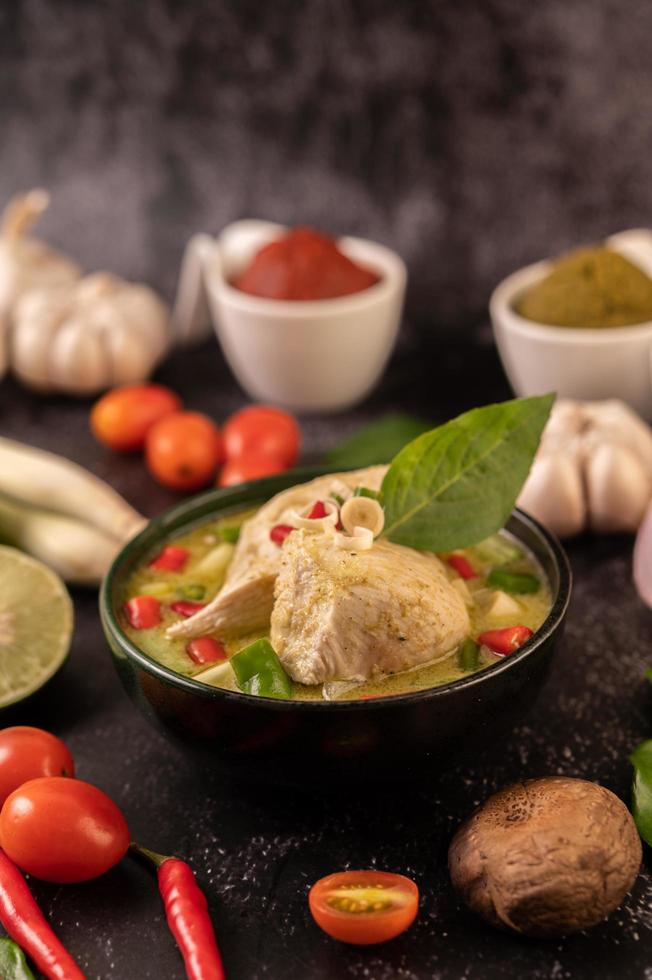 prato de curry verde com frango, pimenta e manjericão e tomate e limão foto