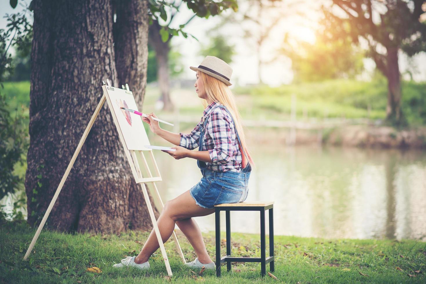 linda garota fazendo um desenho no parque foto