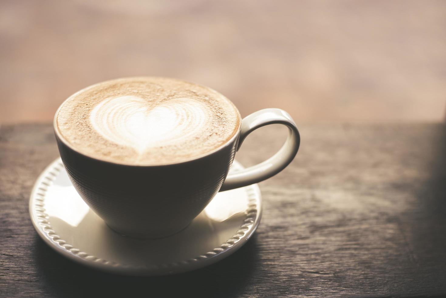 xícara de café quente em tom vintage com arte em formato de coração foto