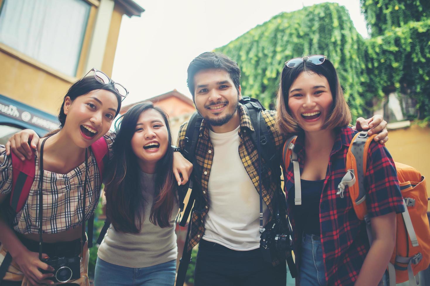 grupo de amigos se encontrando na cidade e sorrindo para a câmera foto