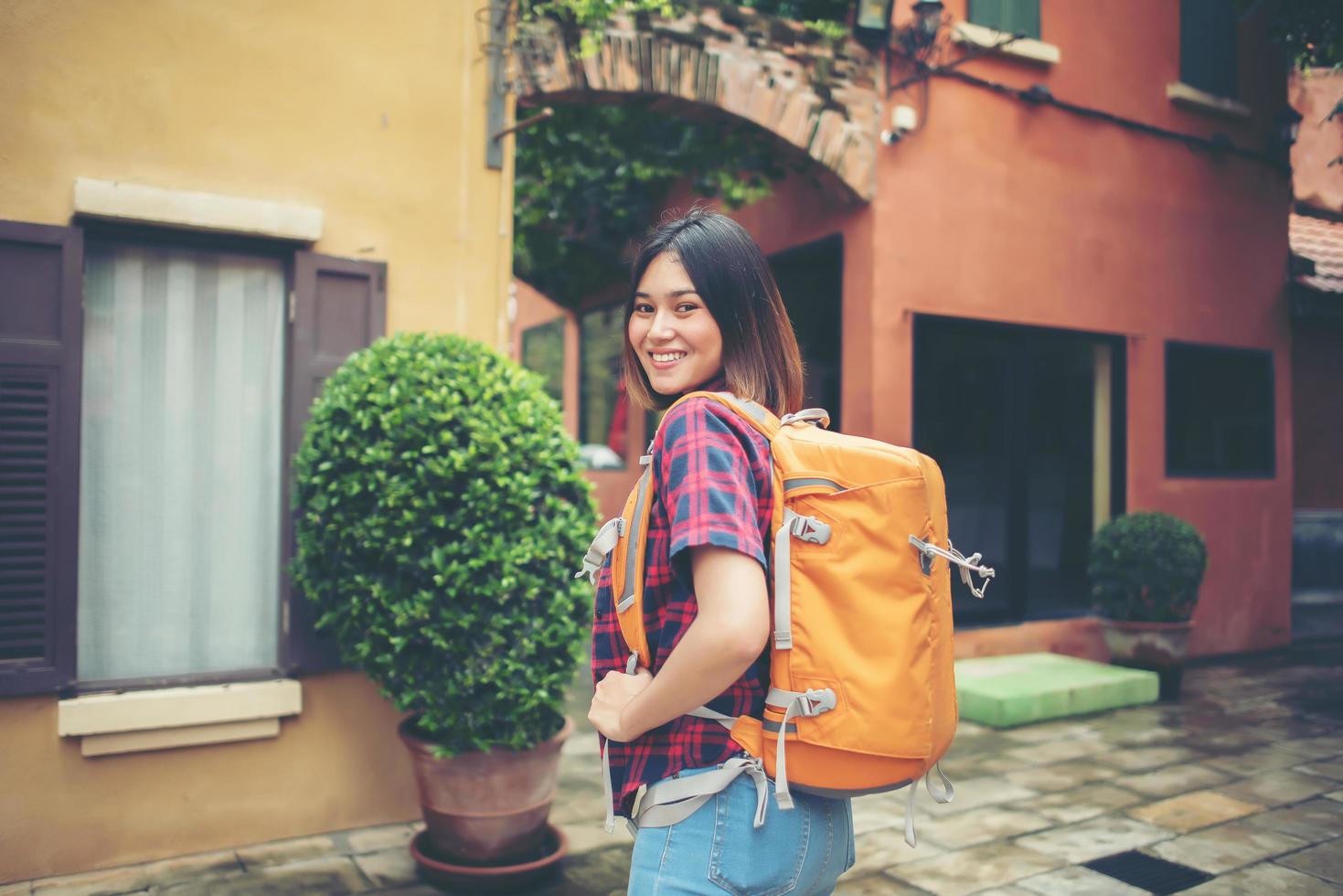 jovem asiática fazendo mochila em uma área urbana foto