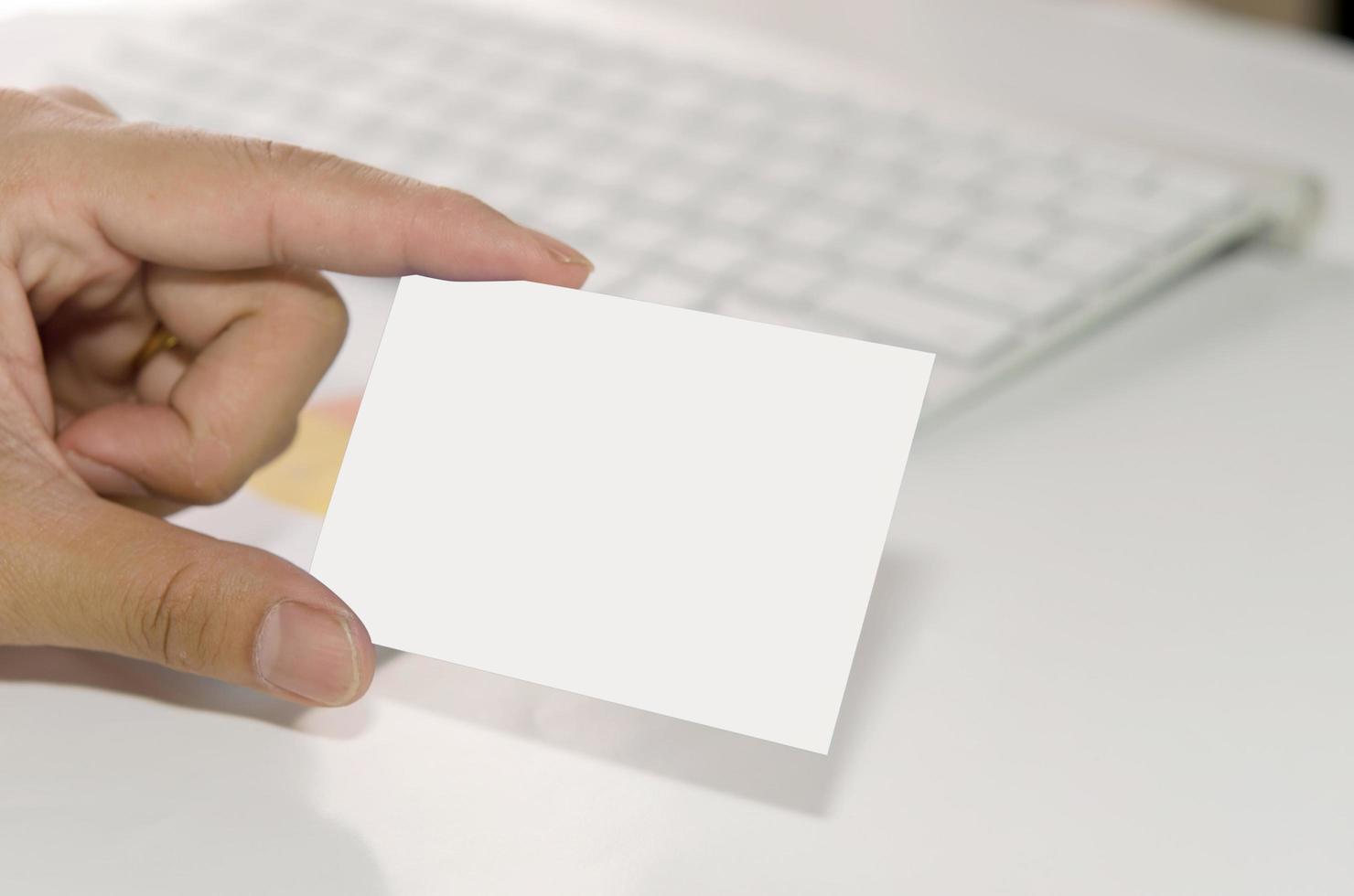 mão segurando um cartão branco foto