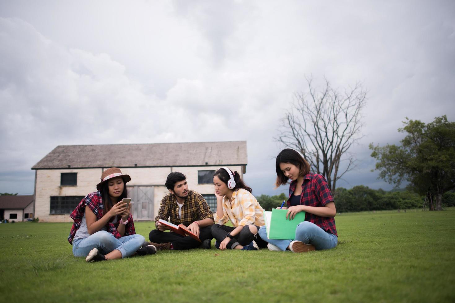 grupo de alunos sentados em um parque depois da aula foto