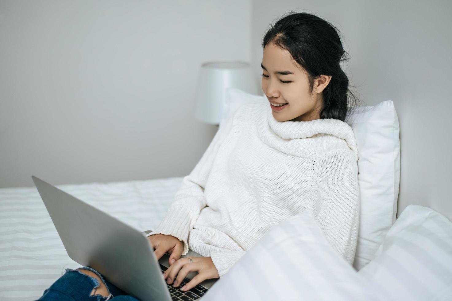 uma jovem feliz brincando em seu laptop foto