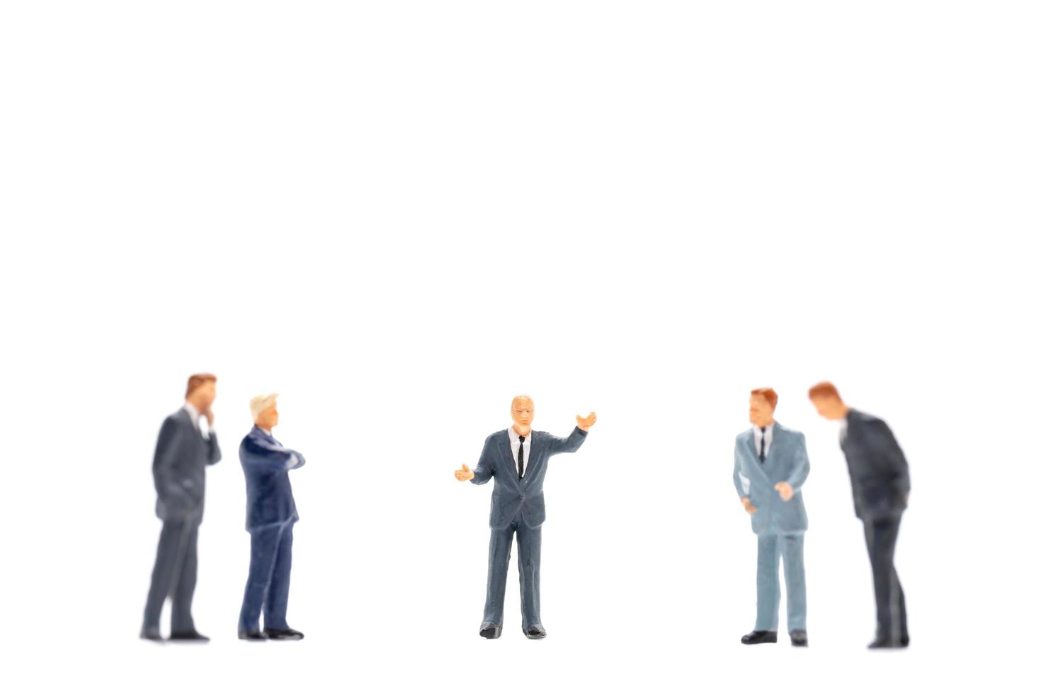 estatuetas em miniatura de executivos em pé sobre um fundo branco foto