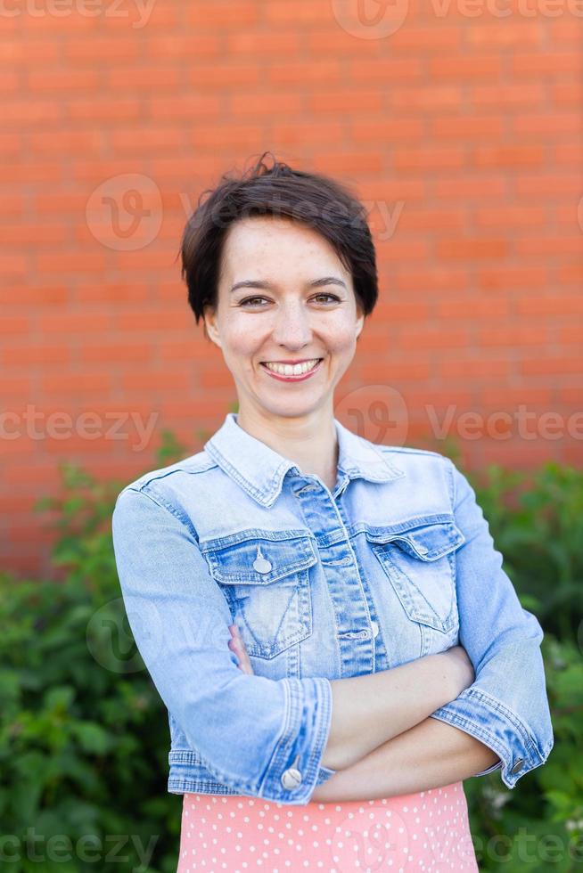 retrato alegre jovem vestido elegante no pátio. garota sorridente feliz fazendo se divertindo ao ar livre. mulher bonita feliz aproveitando o verão foto